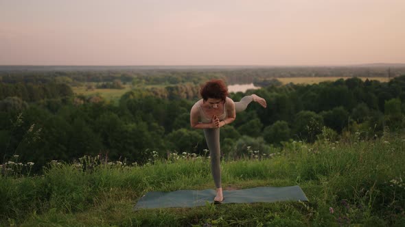 Woman Practises Yoga at Sunrise in Pine Forest