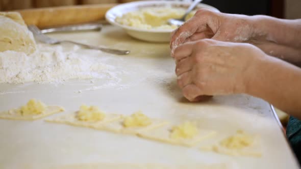 Woman Cooks Dumplings With Potatoes At Home At The Table