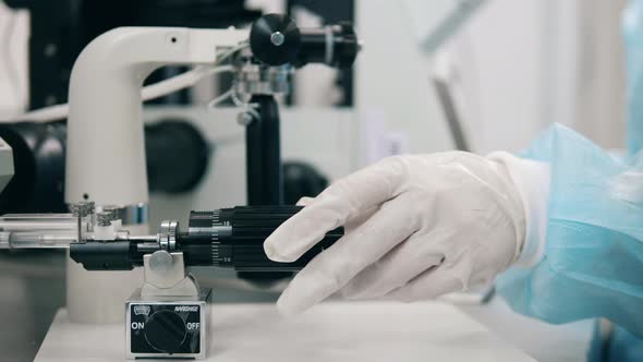 Hospital Worker Uses Microscope in a Room.