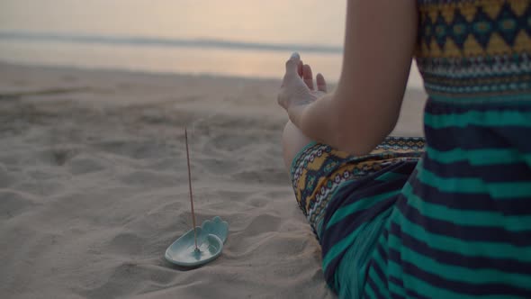 Close Up of Woman in Dress Sitting in Lotus Position and Meditating on the Beach