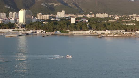 Aerial View Active Sports Person Wakesurfing From Yacht Boat Amazing Sunset Touristic City Seascape