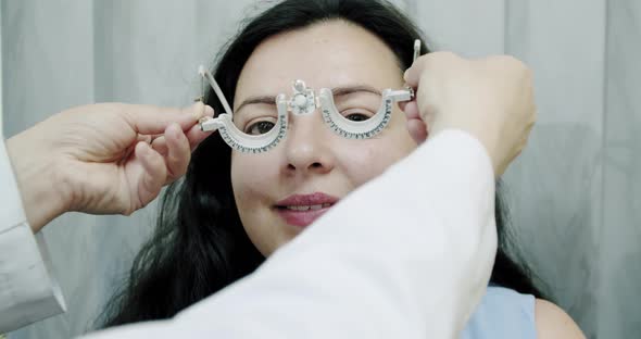 Close Up Eyesight Measurement To Young Woman with Optical Phoropter. Woman Doing Eye Test Slow