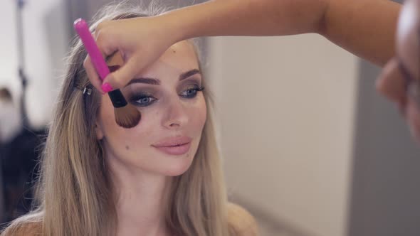 The Makeup Artist Applies the Powder to Finish Client's Makeup Slow Motion