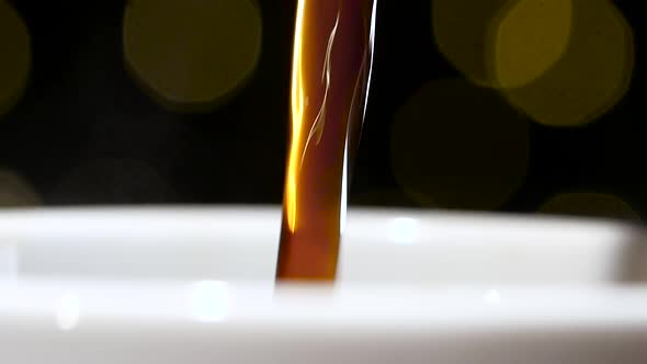 Pouring Jet of Black Coffee in a White Cup. Closeup