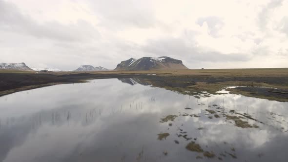 Aerial view of beautiful Iceland countryside with snowy mountain reflecting i