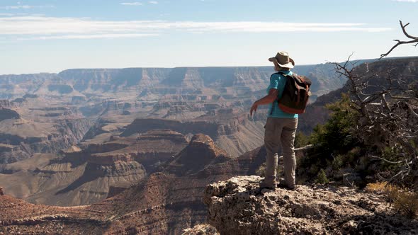 Hiker Active Woman Walks The Edge Of Grand Canyon Cliff And Raises Her Arms Up