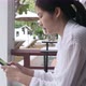 Asian traveler using smartphone at hotel balcony near swimming pool. - VideoHive Item for Sale