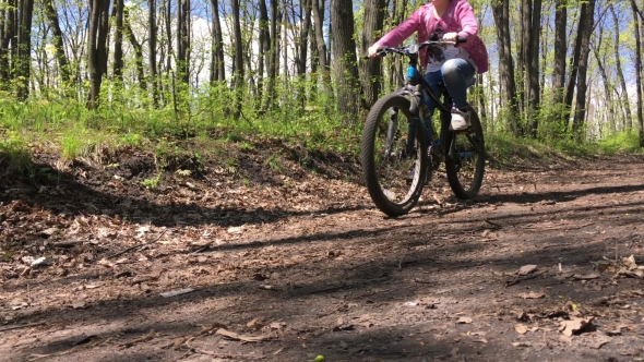 Girl Riding a Bike Through The Woods