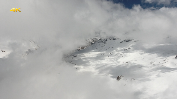 Aerial Snowy Mountains and Valley Through the Cloud