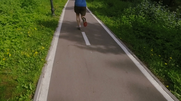 Adult Man Running Jogging Outdoors In a Forest