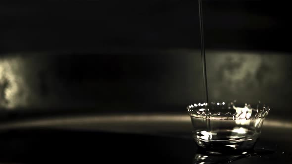 Super Slow Motion Jet Oil Falls on the Pan with Splashes