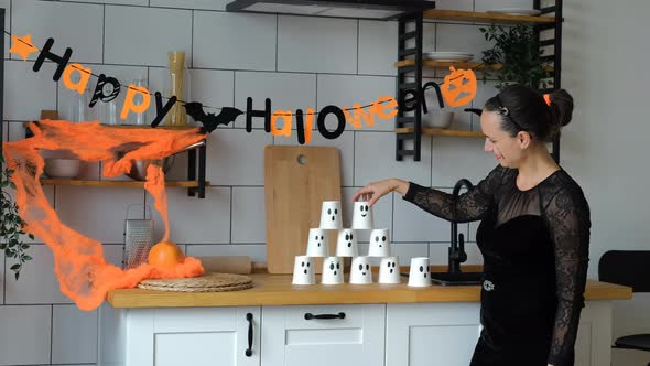Young Woman Decorates Kitchen for Halloween Party