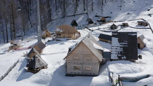 Flying Backward Over Natural Landscape Winter Countryside Wooden Roof Village Hut Snowy Mountains