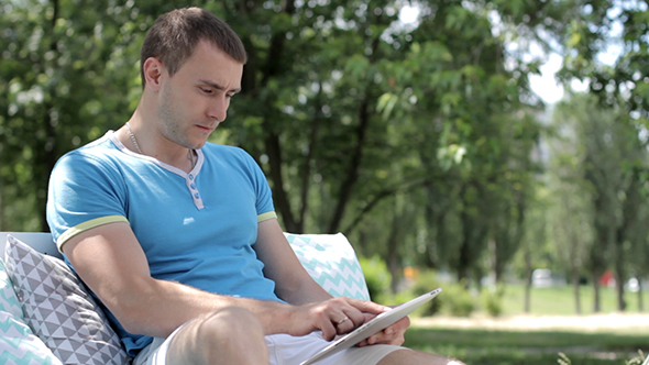 Young Man Uses Tablet Outdoors