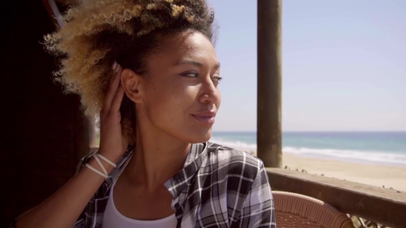 Adorable Afro Girl Sitting In Beach Bar