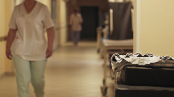 View Of Corridor In Maternity Hospital. Nurses And Doctors In Medical Uniform. Maternity Home.