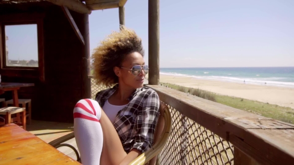 Young Woman Relaxing At a Beachfront Cafeteria