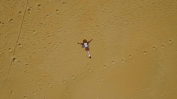 View From Above Of Woman Laying In Sand