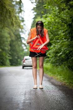 /safety vest, putting in place the warning triangle after her car has broken down