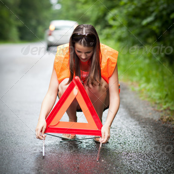 /safety vest, putting in place the warning triangle after her car has broken down