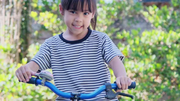 Cheerful smiling girl ringing a bicycle.