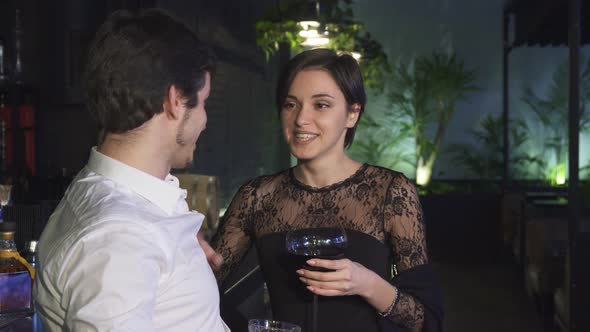 Young Woman Having Drinks at the Bar with Her Boyfriend