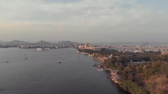 Wide Panoramic view of Pichola lake bank with Taj lake palace in the distance at sunset, Udaipur