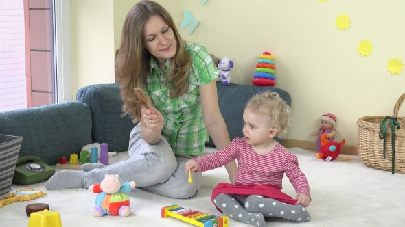 Daughter Play Glockenspiel And Mother Shake Wooden Rattle. Family Have Fun