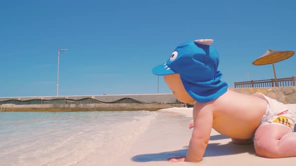 For the First Time, a Child Near the Ocean with His Mother Touches Salt Water 