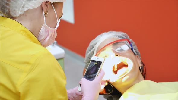 Professional Dentist at Work Photographs Teeth After Treatment. A Person Undergoes a Medical