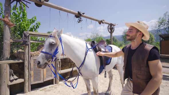 The man dismounts loves his horse and kisses it.