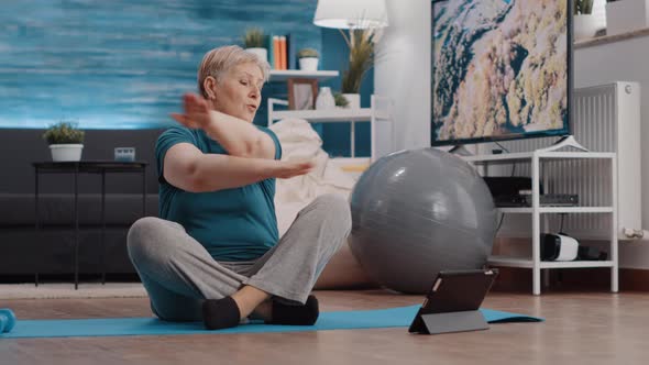 Elder Person Doing Physical Exercise and Watching Online Lesson