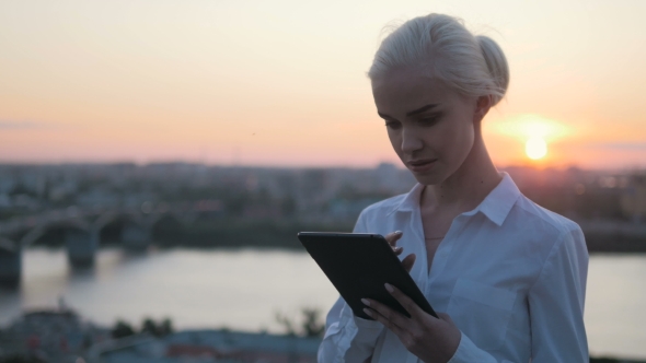 Young Beautiful Business Woman Using Tablet PC Outdoors In Sunset Backlight