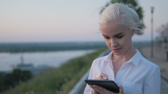 Young Beautiful Business Woman Using Tablet PC Outdoors On The Sunset