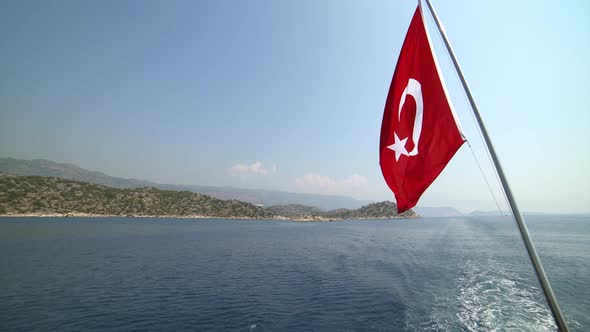 Turkish Flag Waving Behind the Boat, Symbolizing the Sea Holiday and Tourism in Turkey