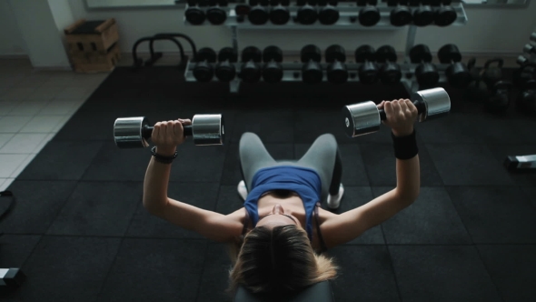 Athletic Girl In Gym Do Dumbbell Press On An Incline Bench