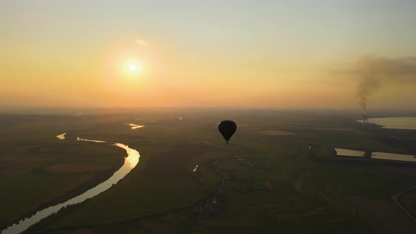 Aerial View of Big Hot Air Baloon Flying Over Rural Countryside at Sunset