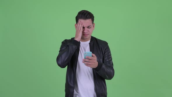 Stressed Young Multi Ethnic Man Using Phone and Getting Bad News