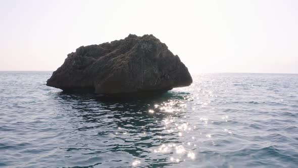 Big Rocky Stone in Wavy Sea Water