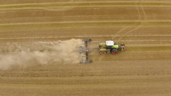 Tractor plows the field aerial. 