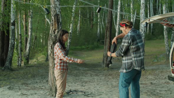 Couple Preparing Poles for Setting Up Tent at Campsite