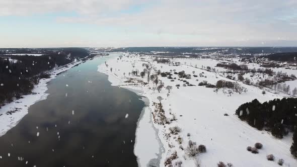 Winter wonderland and Nemunas river during snowfall, aerial drone view