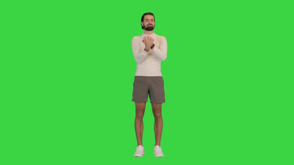 Man Stretching Forearm Before Exercising on a Green Screen Chroma Key