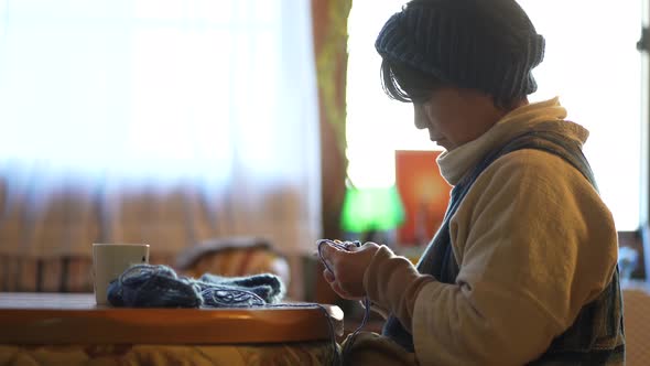 A woman knitting a neck warmer