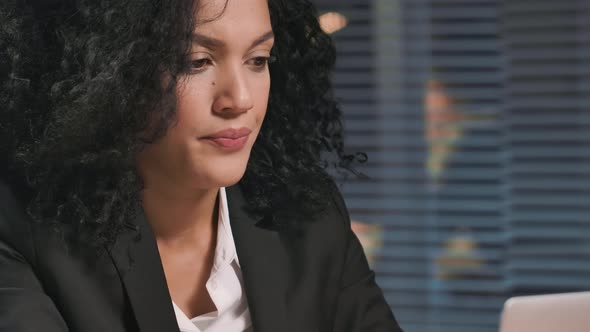 Portrait of African American Woman in Business Suit Intently Typing on Laptop