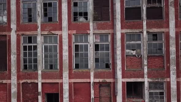 Brick Facade of an Abandoned Old Industrial Building with Broken Windows