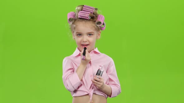 Little Girl Paints Her Lips with Beautiful Lipstick. Green Screen