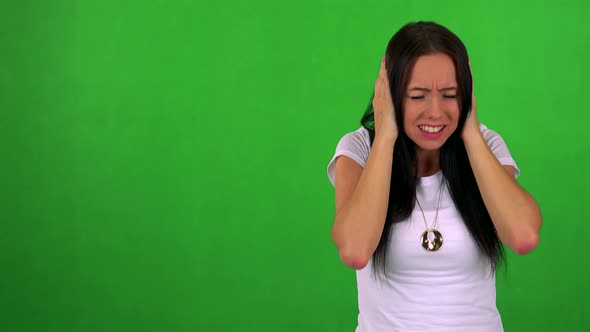 Young Pretty Woman Is Afraid (Woman Covers His Ears with Hands) - Green Screen - Studio