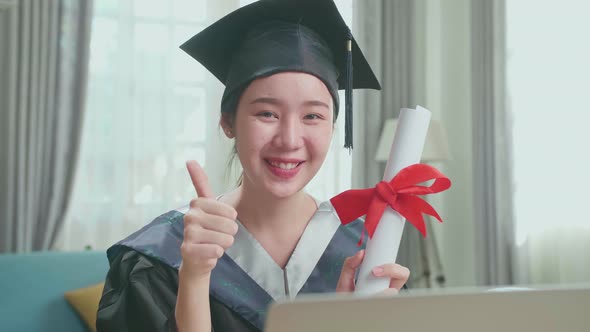 Excited Asian Woman Holding A University Certificate, Smiling And Thumb Up To Camera