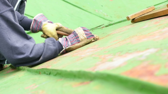Worker Scraping Off Green Paint